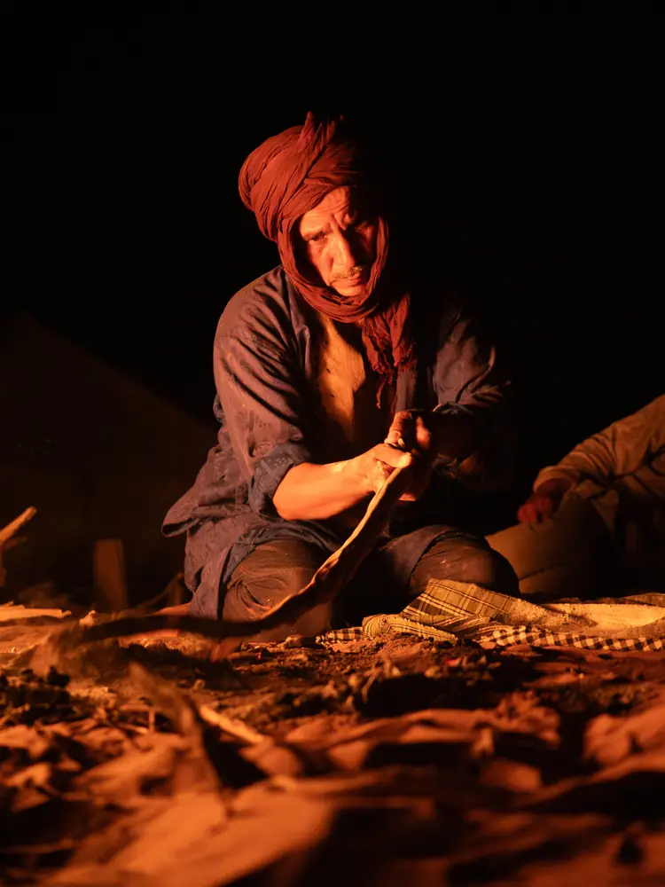 Guide préparant le feu de bivouac de nuit