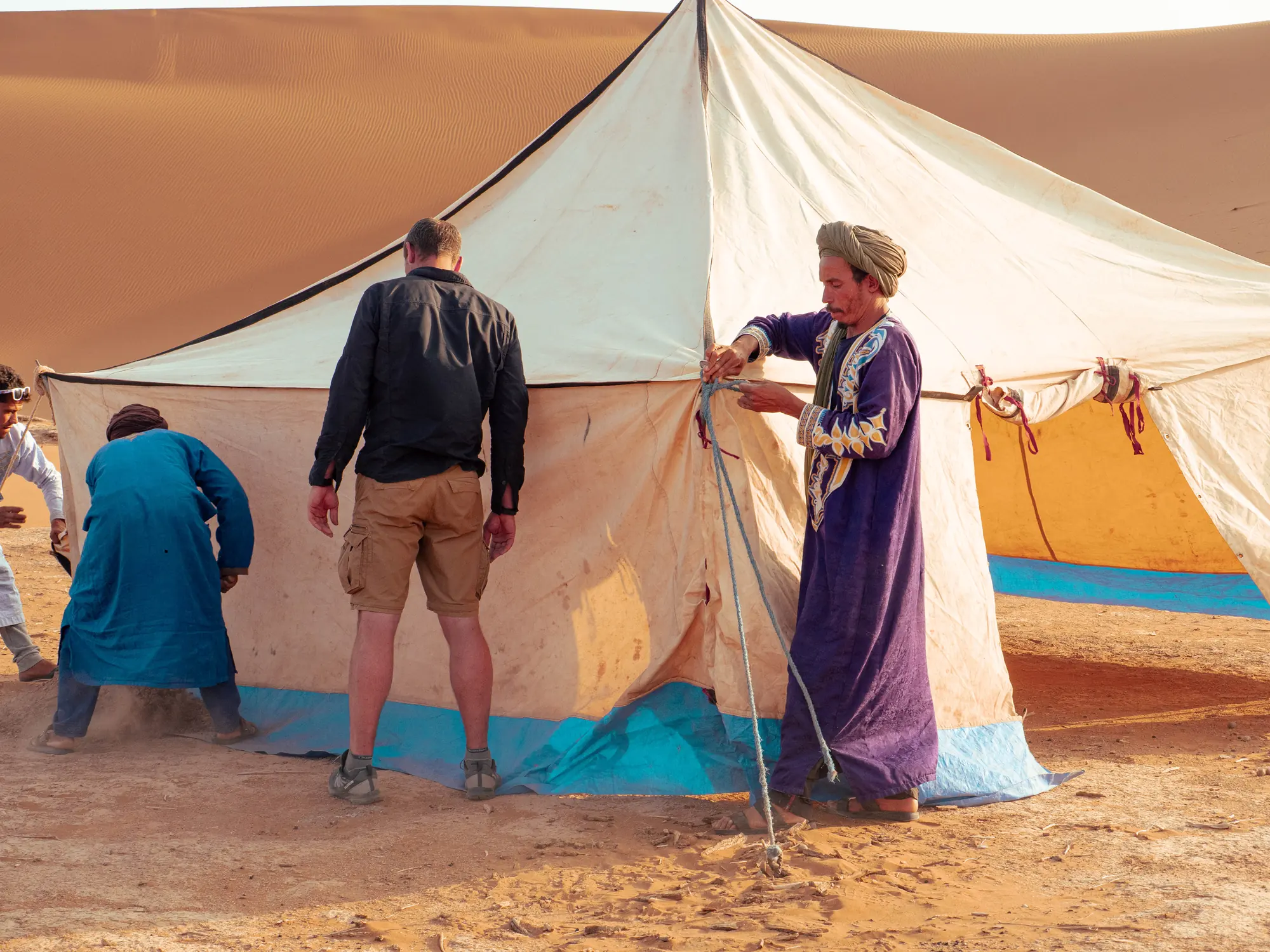 Installation du campement : Laurent et l'équipe de guides dressant la tente dans le désert
